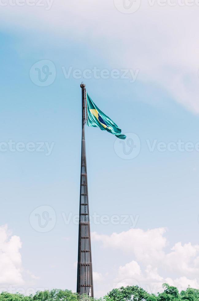 brasiliansk flagga flygande, fladdrande i de vind och med de blå himmel i de bakgrund. foto