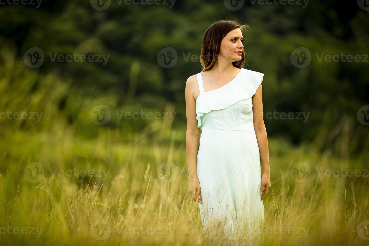 ung gravid kvinna som kopplar av utanför i naturen foto