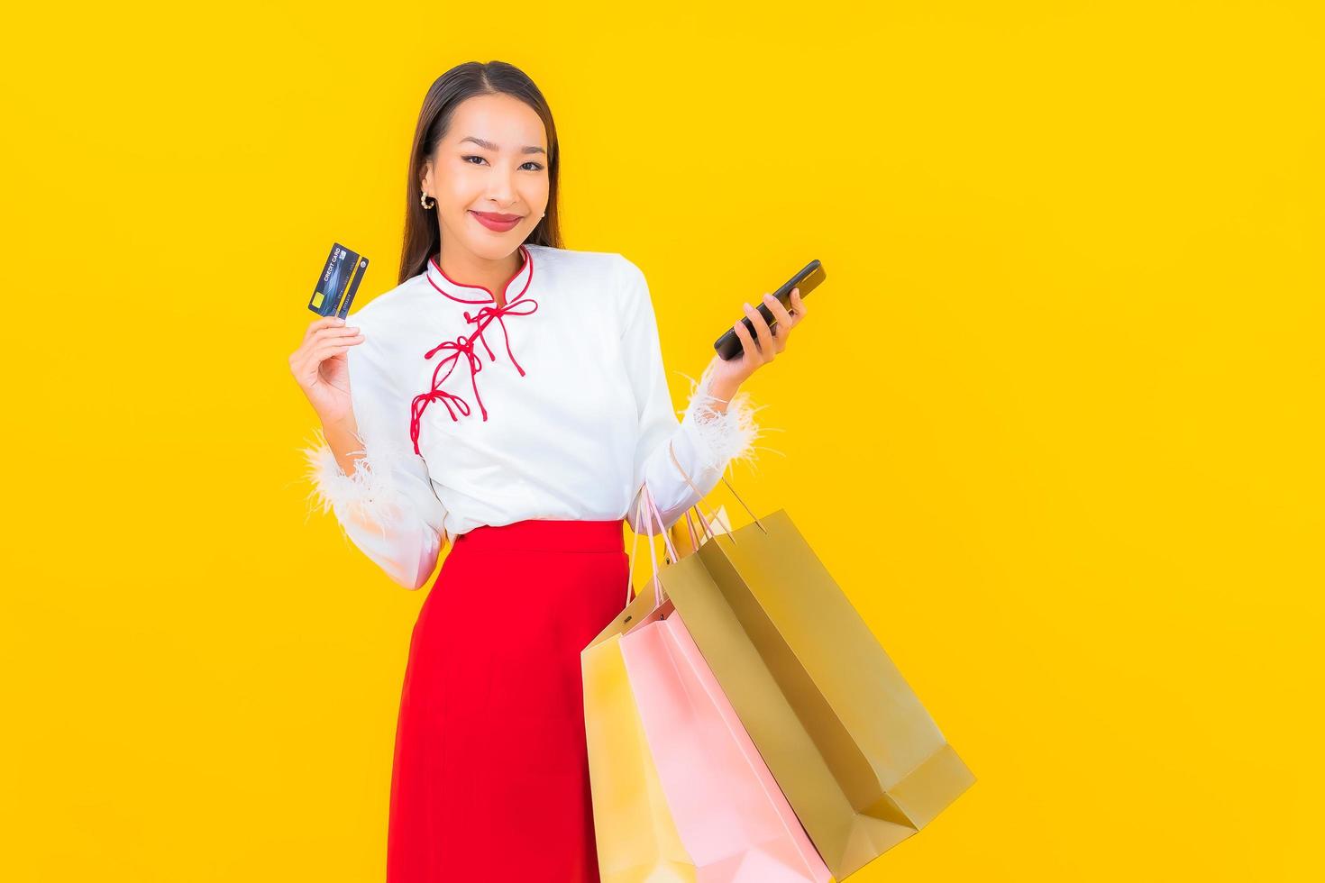 ung asiatisk kvinna med kreditkort och shoppingpåse foto