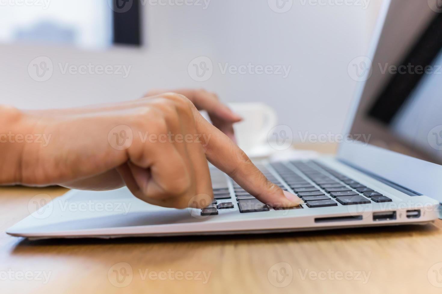 person som använder en bärbar dator på ett skrivbord foto