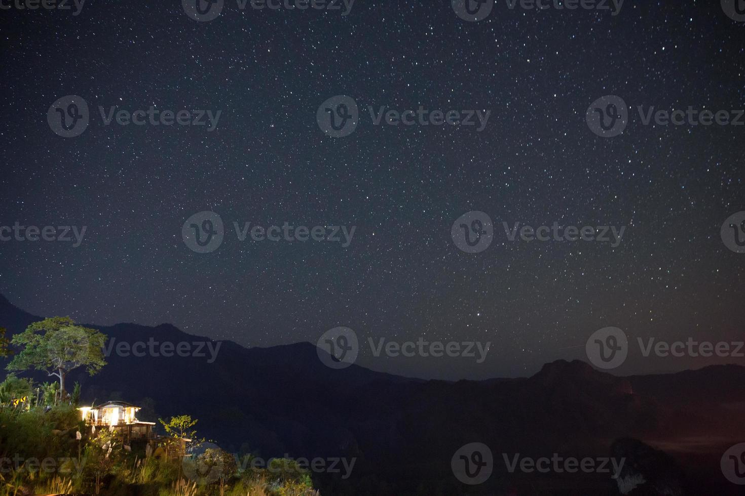 Vintergatan och stjärnor över bergen på natten foto