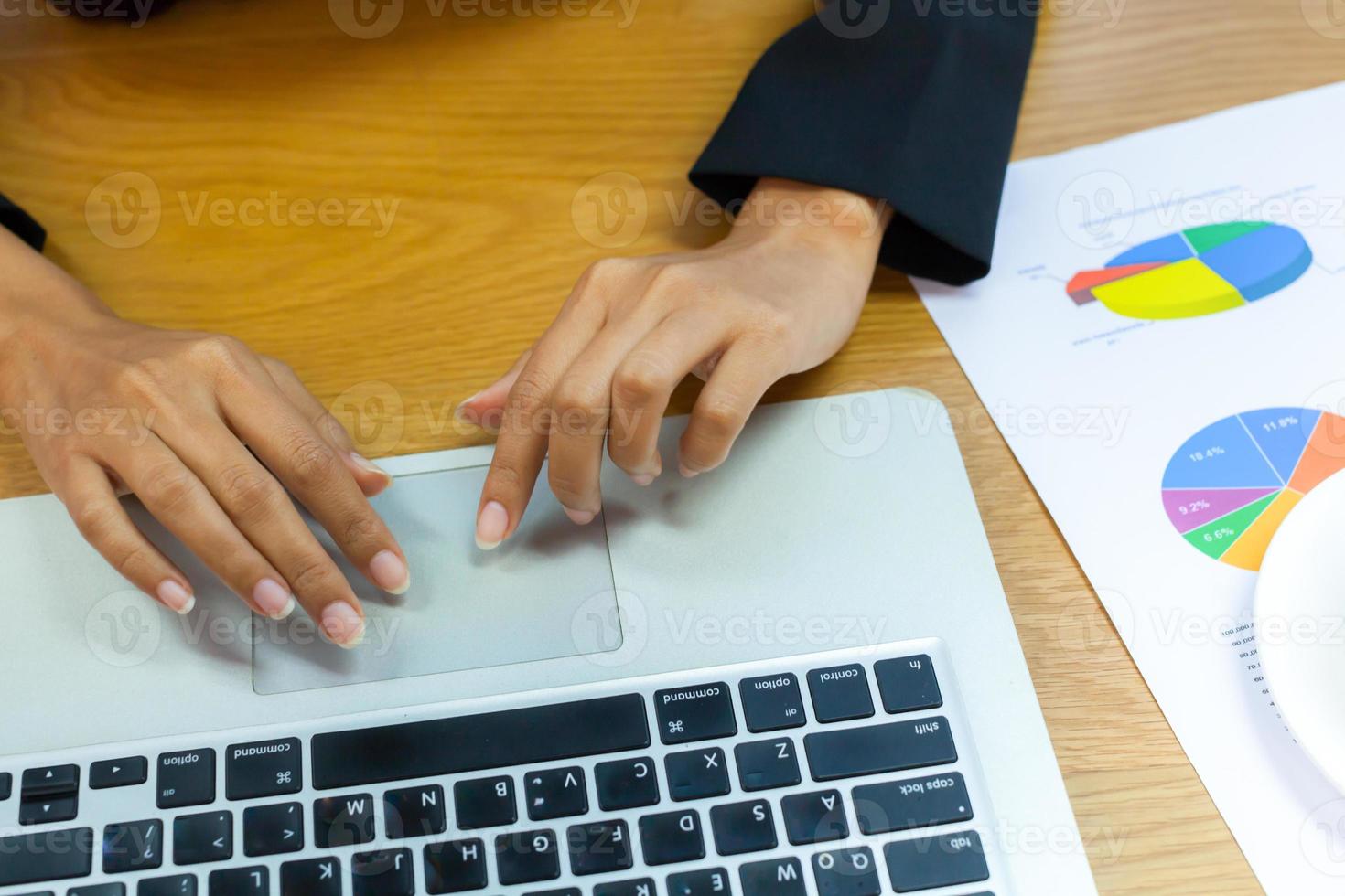person som arbetar på en bärbar dator på ett skrivbord foto