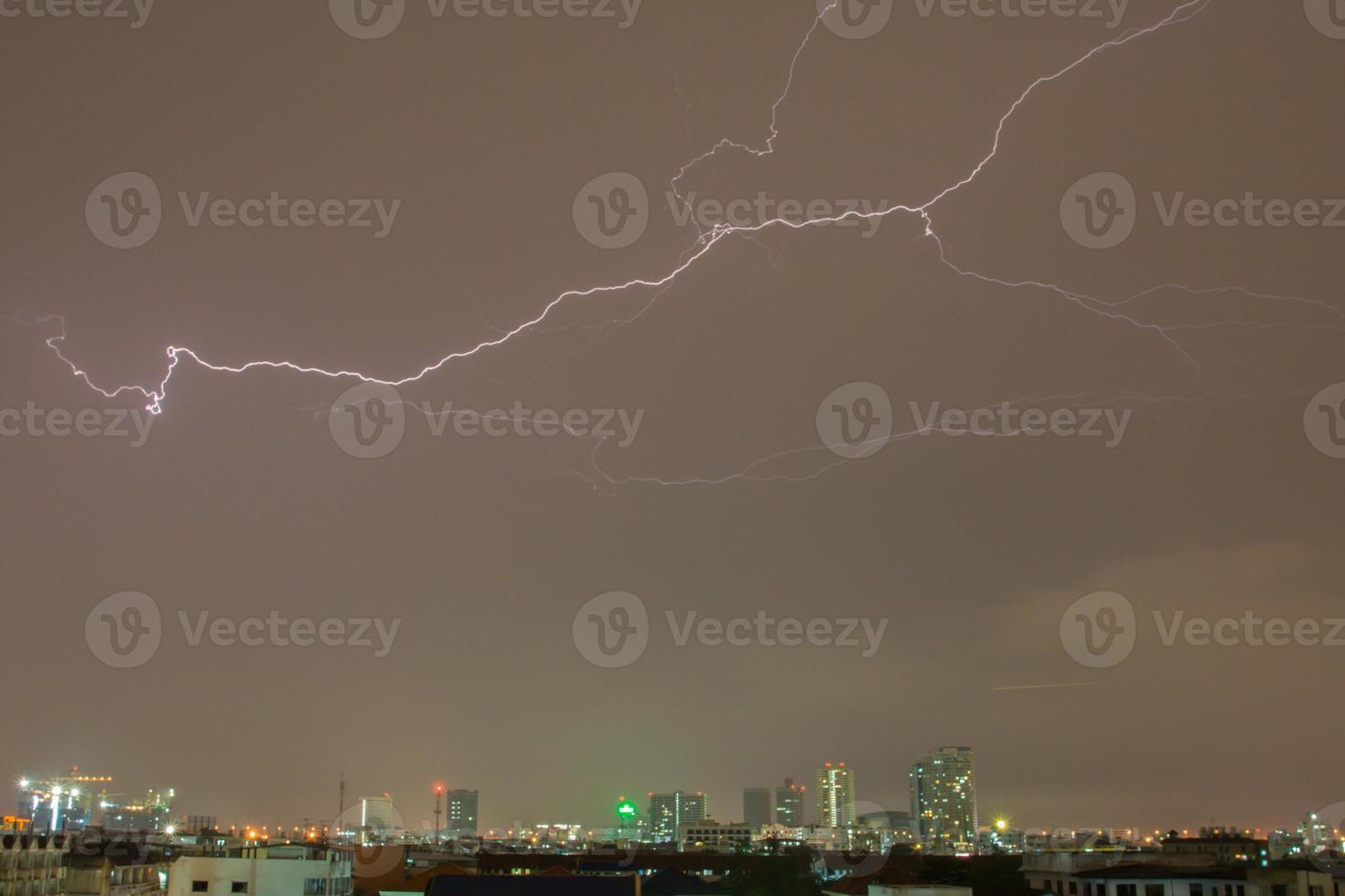 blixtar på himlen över en stad foto