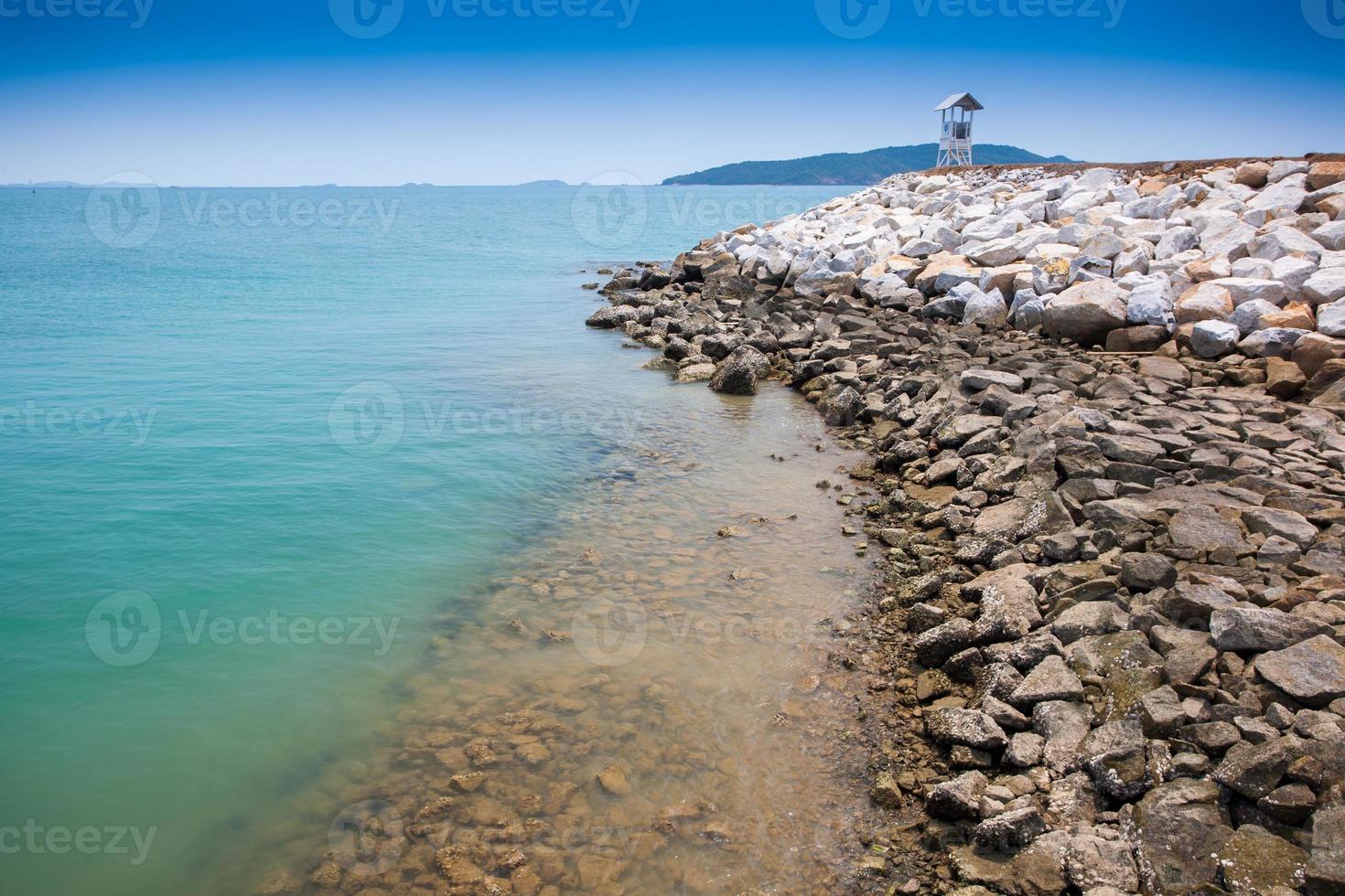 stenig strand och klart blått vatten foto