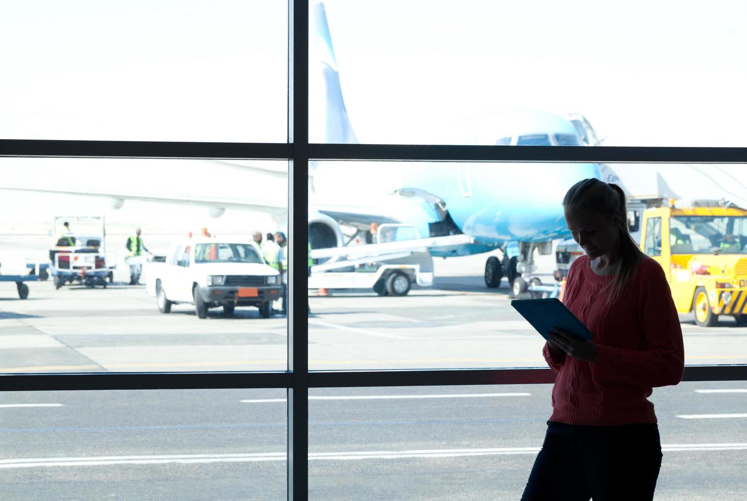 kvinna som använder en tablett på flygplatsen foto