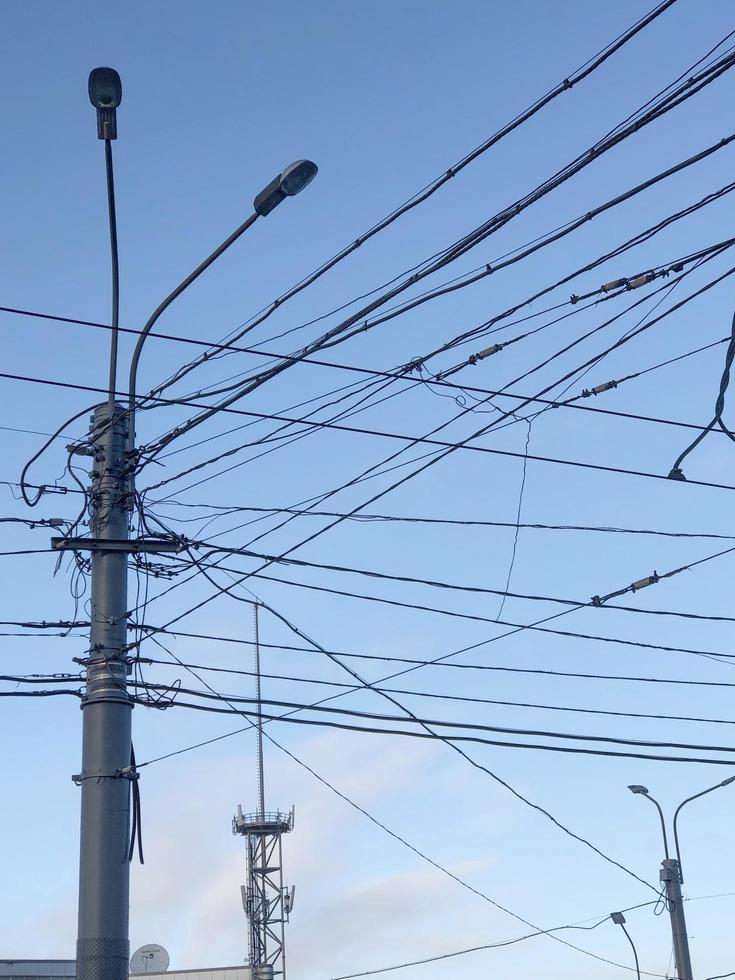 Pol med många elektrisk trådar i de stad himmel foto
