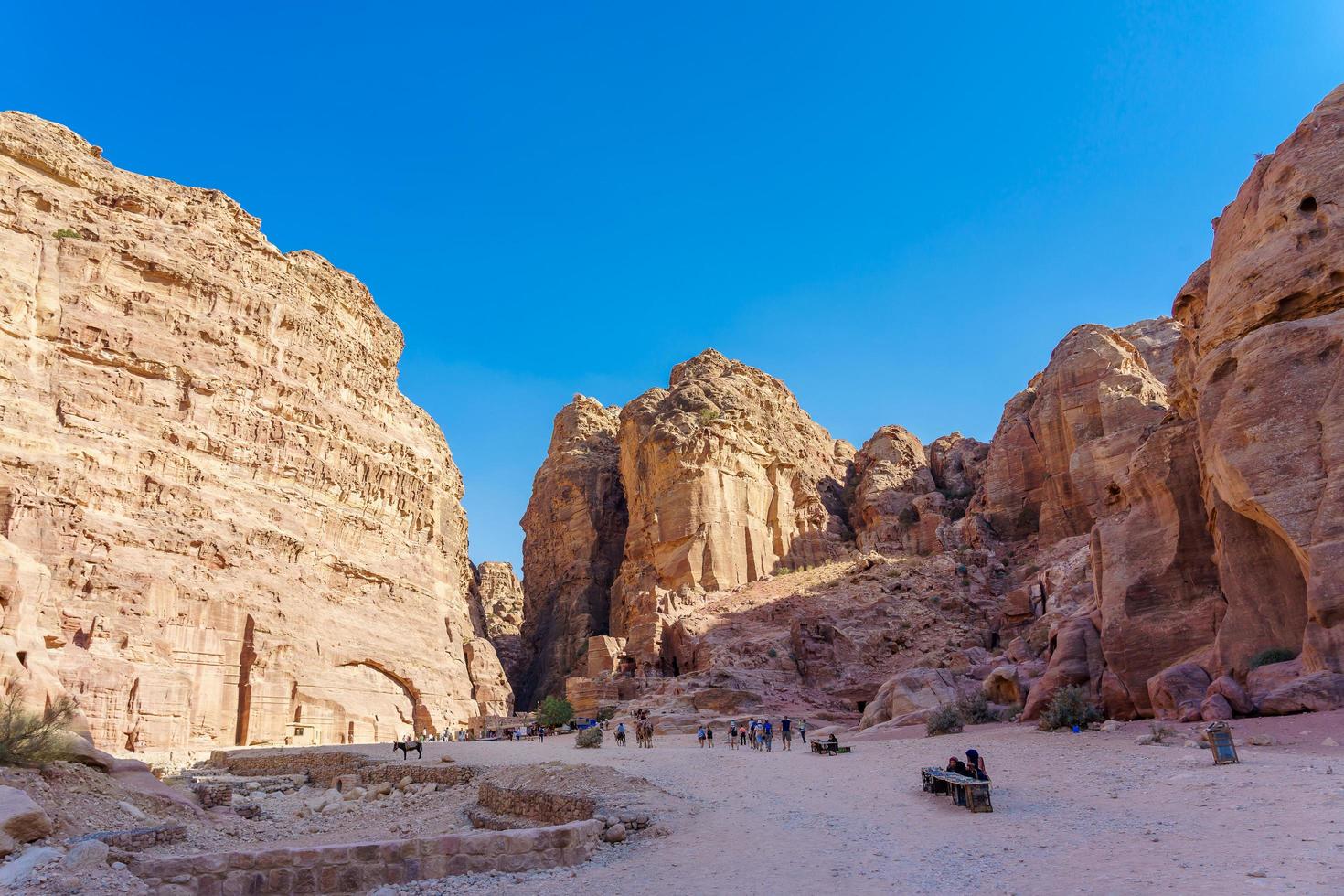 turister i den smala passagen av stenar i petra canyon i Jordanien foto