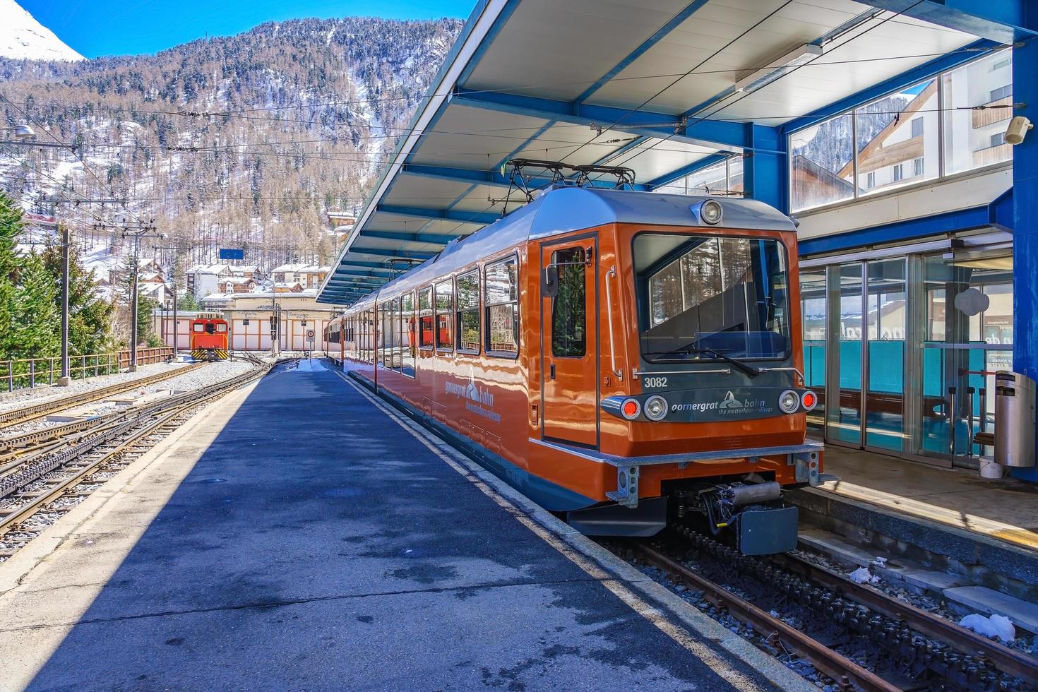 rött tåg som klättrar upp till gornergrat station på Zermatt, Schweiz foto
