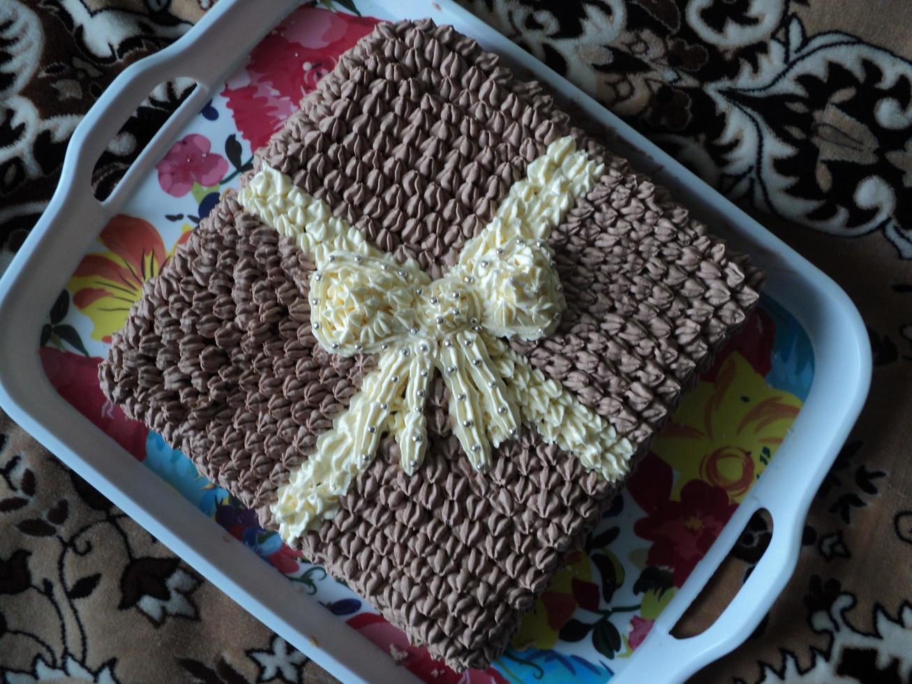 choklad kaka i de form av en gåva med en rosett. Foto från telefon.