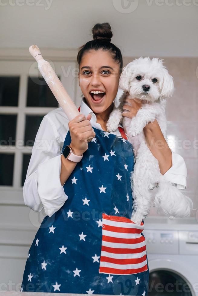 glad kvinna med en rullande stift och vit maltese hund foto