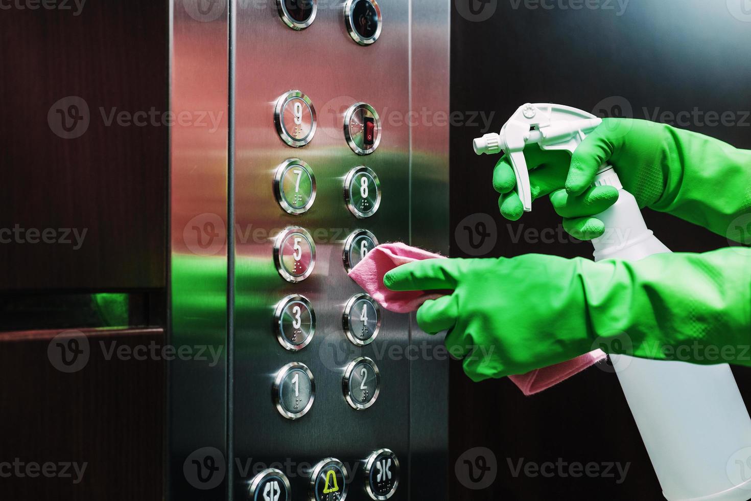 desinfektion av de hiss med en desinfektionsmedel och en servett. foto