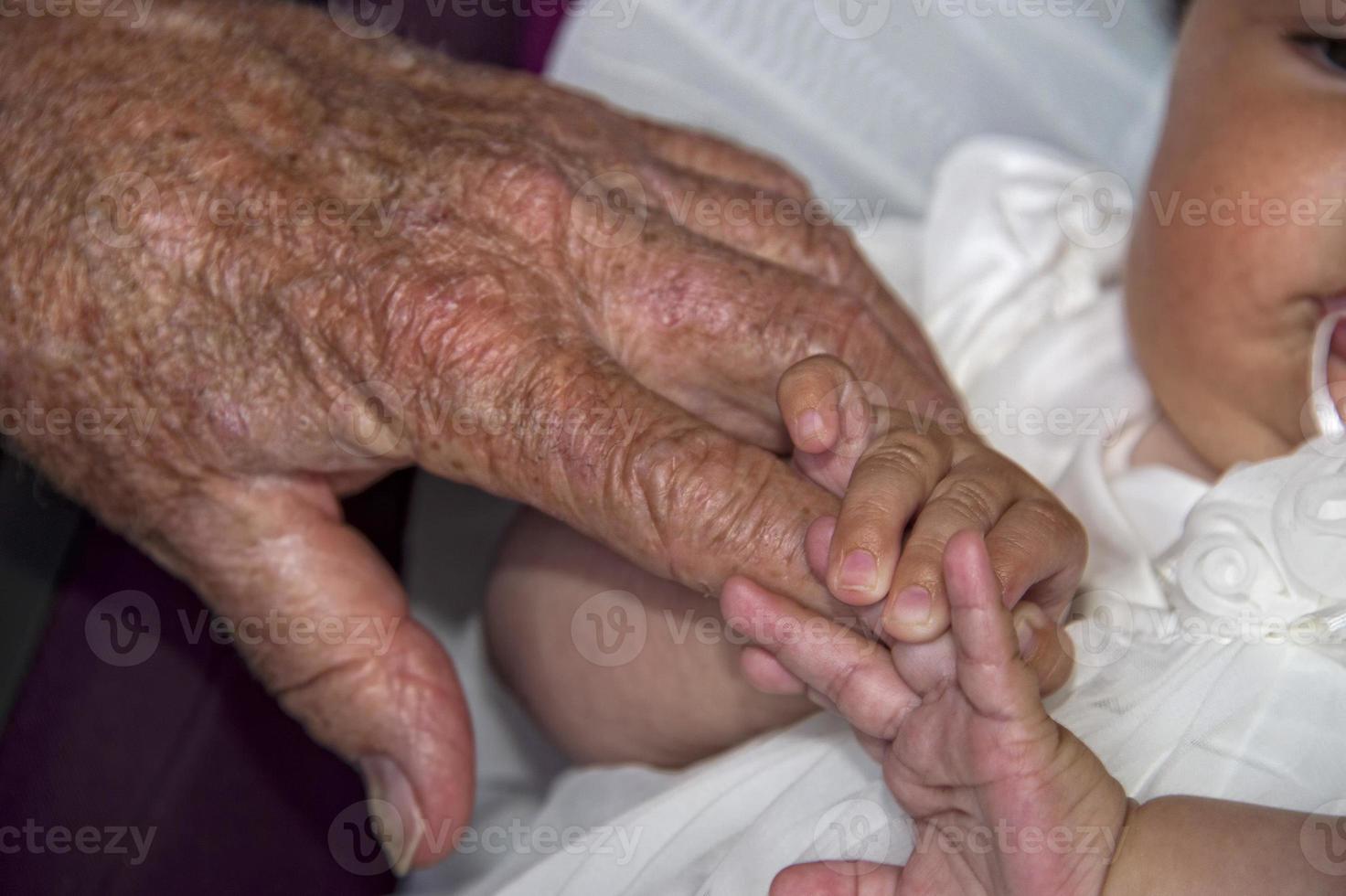 gammal pensionerad man händer innehav nyfödd spädbarn ett foto