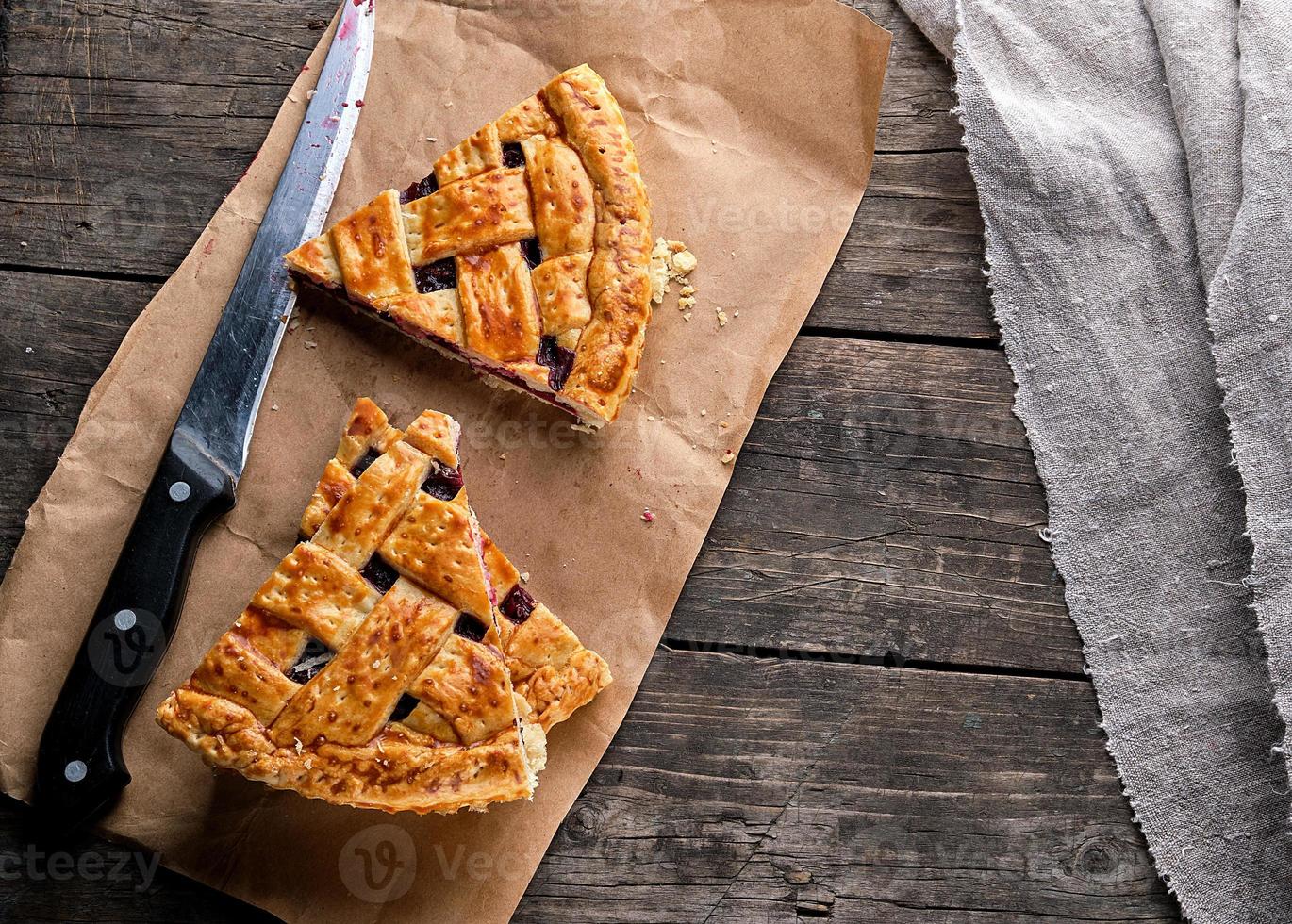 bakad kakor med en körsbär och en kök kniv är på brun papper foto