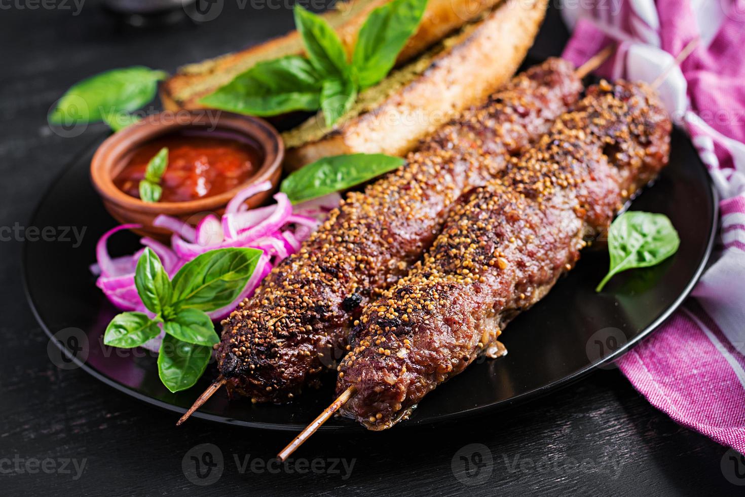 kebab adana, lamm och nötkött och skålar med pesto sås. foto