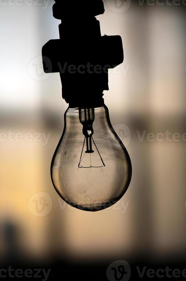 en ljus Glödlampa över de svart bakgrund foto