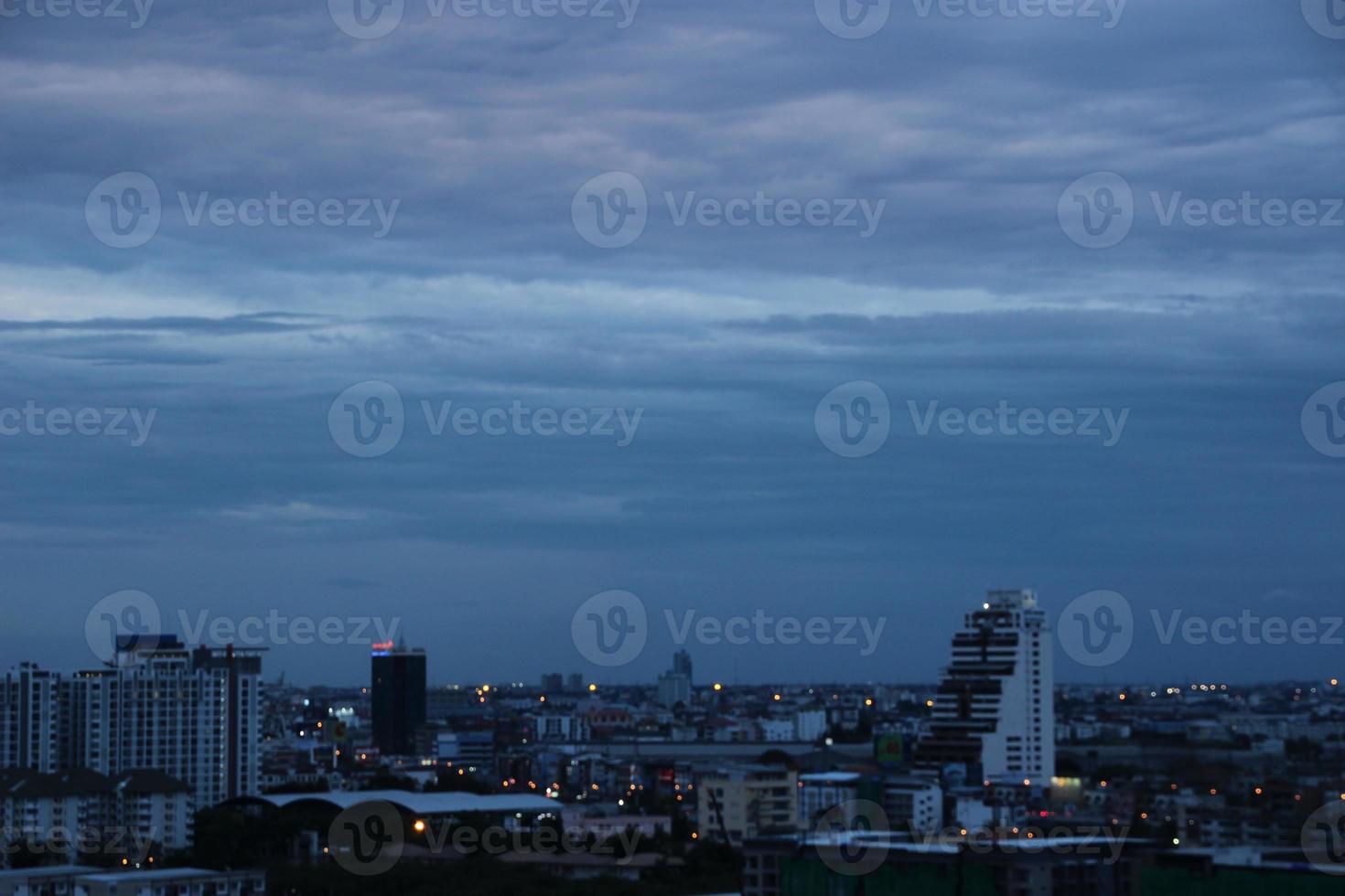 mörk blå moln med vit ljus himmel bakgrund och stad ljus midnatt kväll tid foto