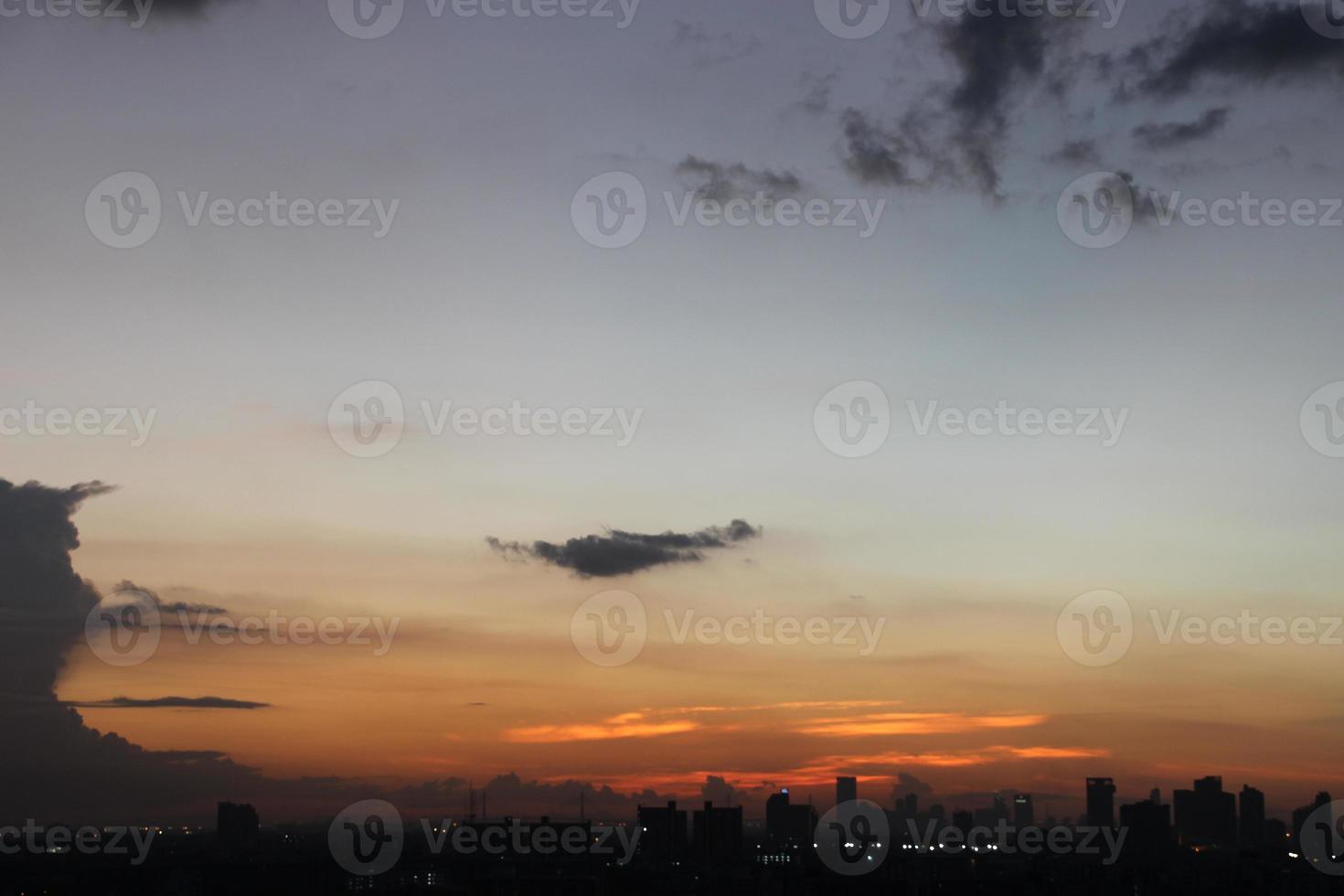 solnedgång mörk blå moln med vit gyllene ljus himmel bakgrund och stad ljus midnatt kväll tid foto