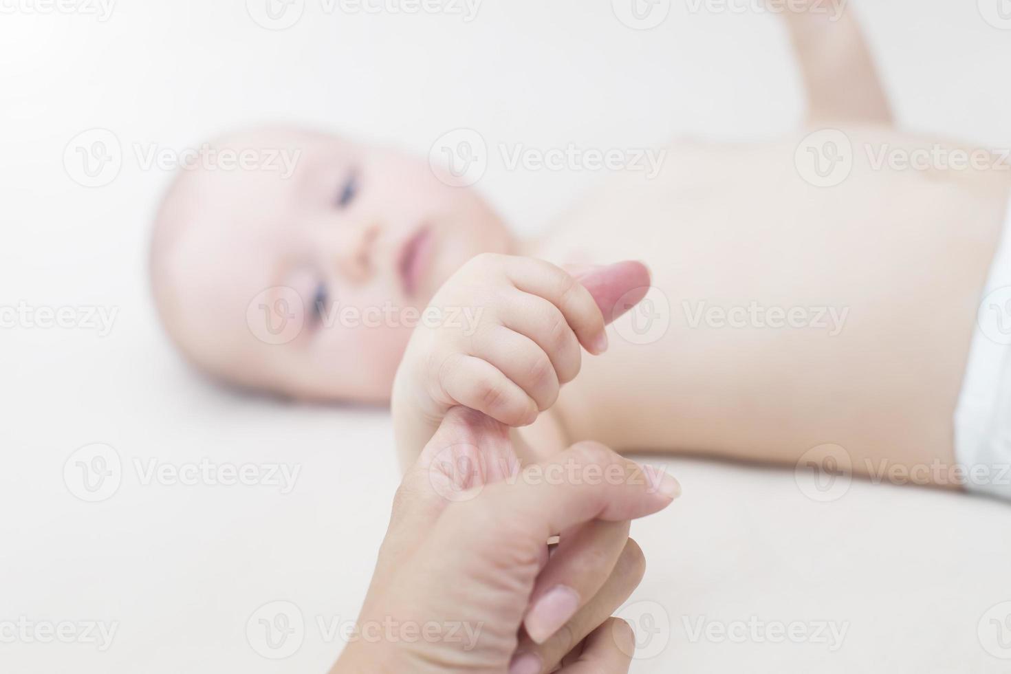 baby flicka håller mödrar finger foto
