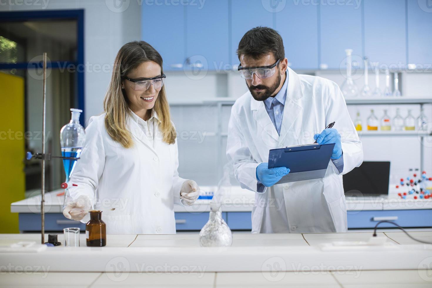 forskare gör experiment med rök på ett bord i ett kemilaboratorium foto