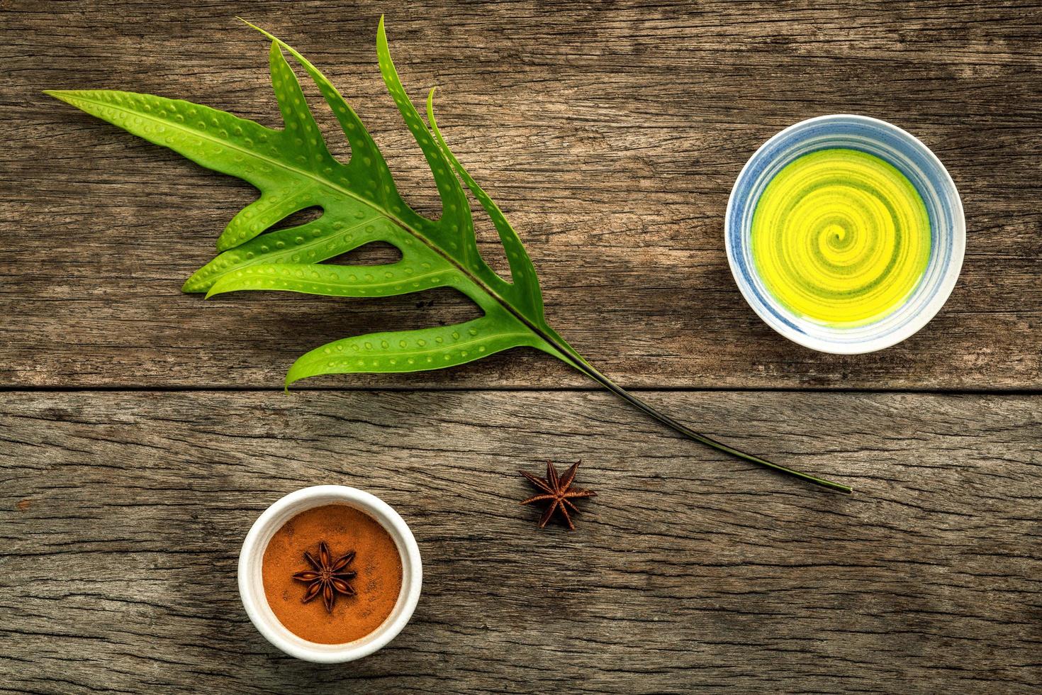 gröna blad och med aromatisk olja och stjärnanis på en rustik bakgrund foto
