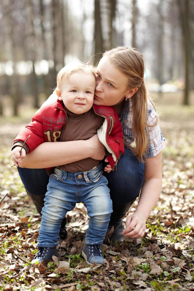 mamma som omfamnar son i en park foto