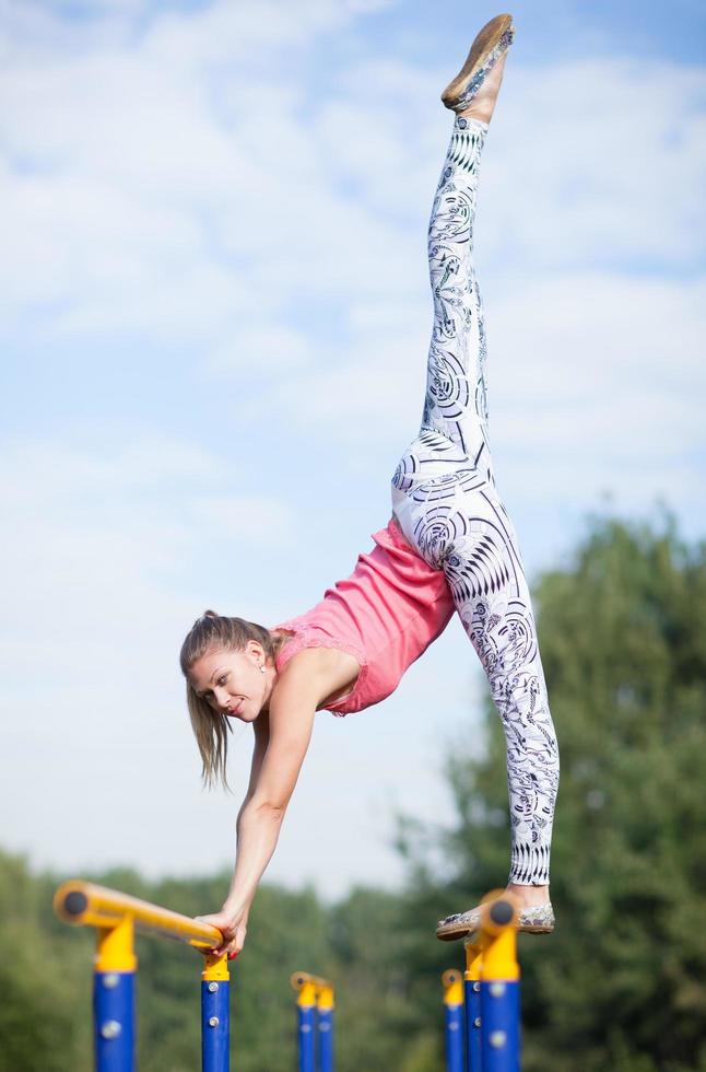 ung gymnast balanserar på tvärstänger foto