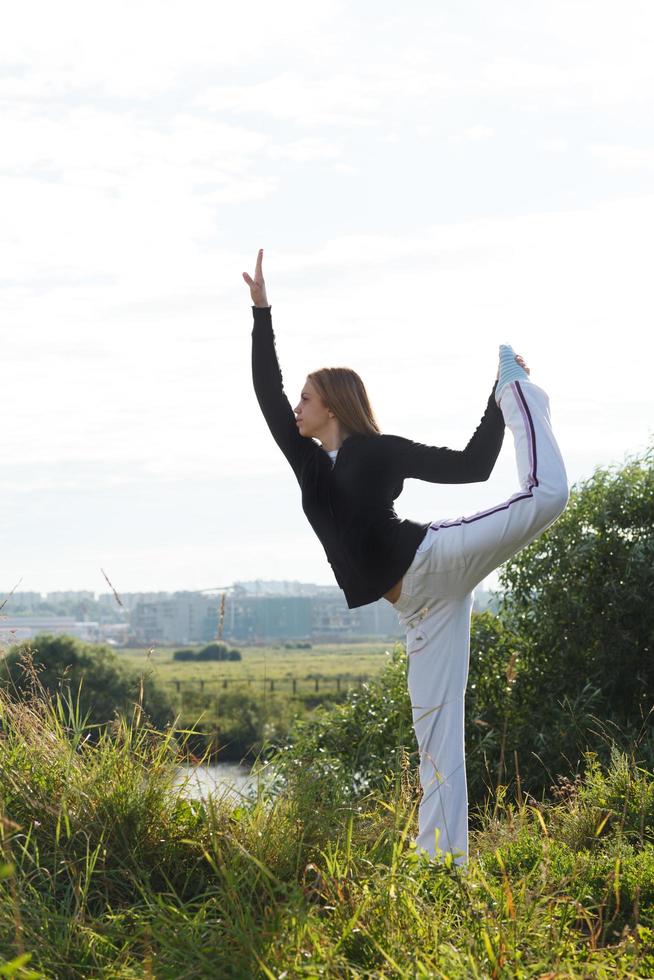 kvinna som utövar yoga utanför foto