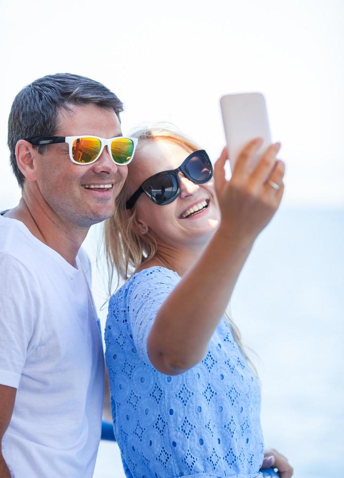 glada par i solglasögon tar en selfie foto