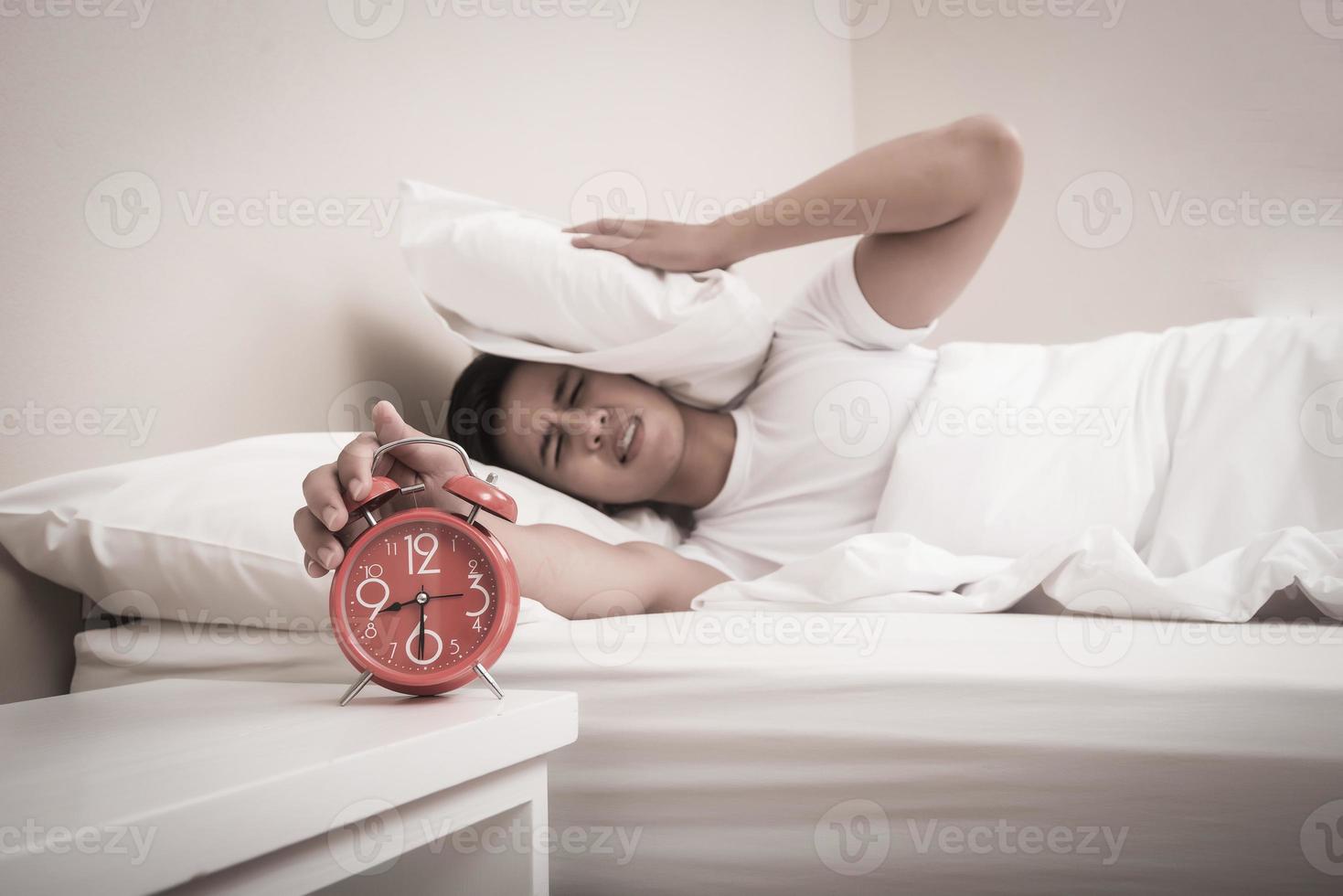 mannen stänger av väckarklockan på morgonen foto