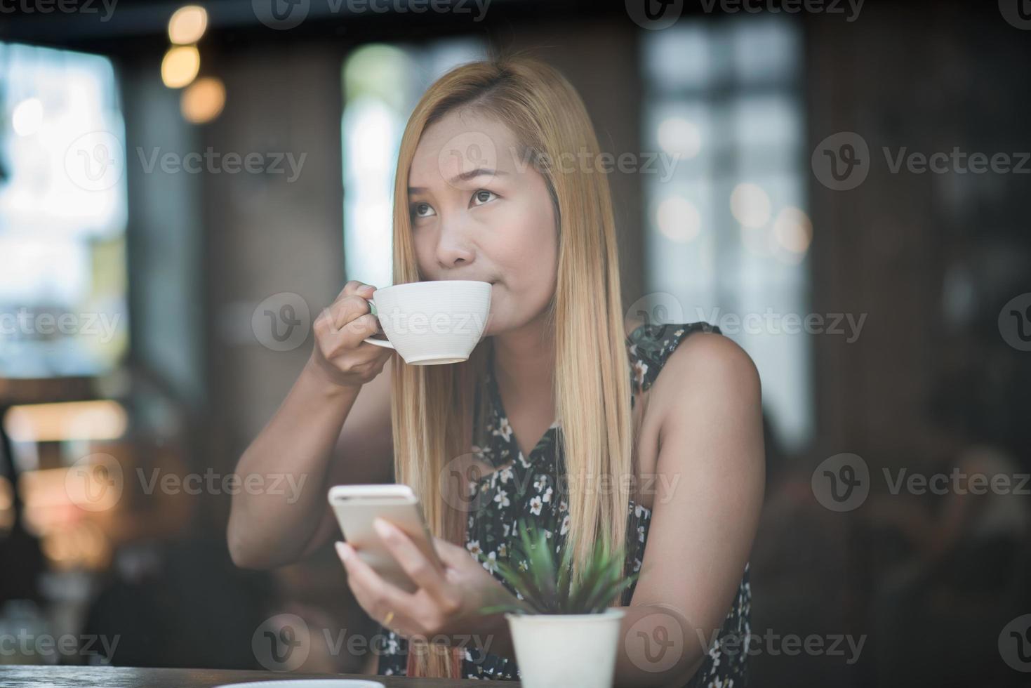 vacker kvinna på ett kafé som dricker kaffe foto