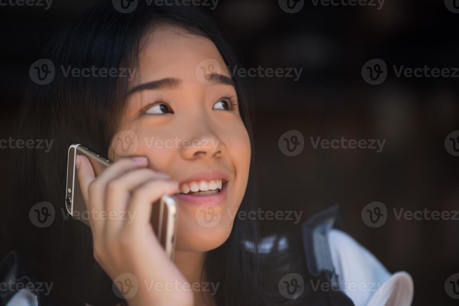 unga kvinnor som använder och tittar på smarttelefonen på fönsterkaféet foto