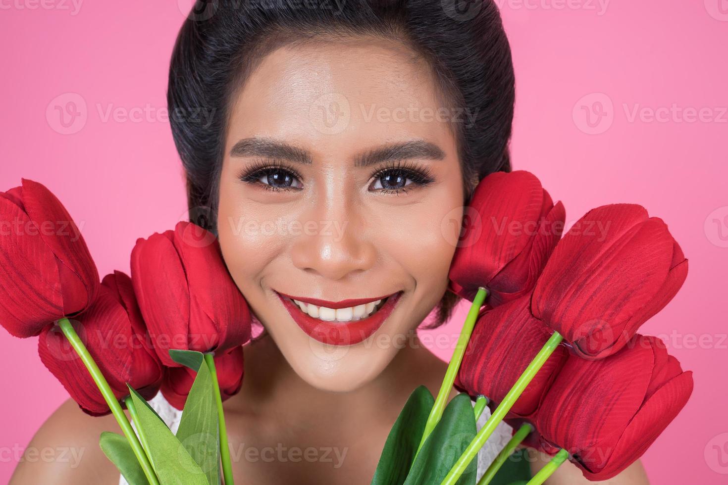 porträtt av en vacker kvinna med bukett med röda tulpanblommor foto