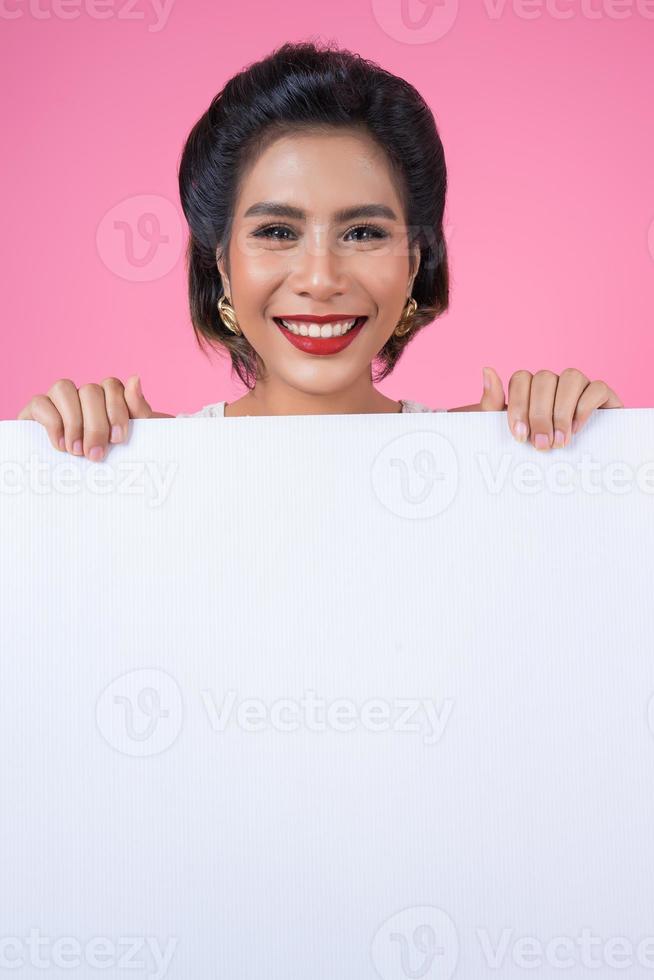 porträtt av en trendig kvinna som visar en vit banderoll foto