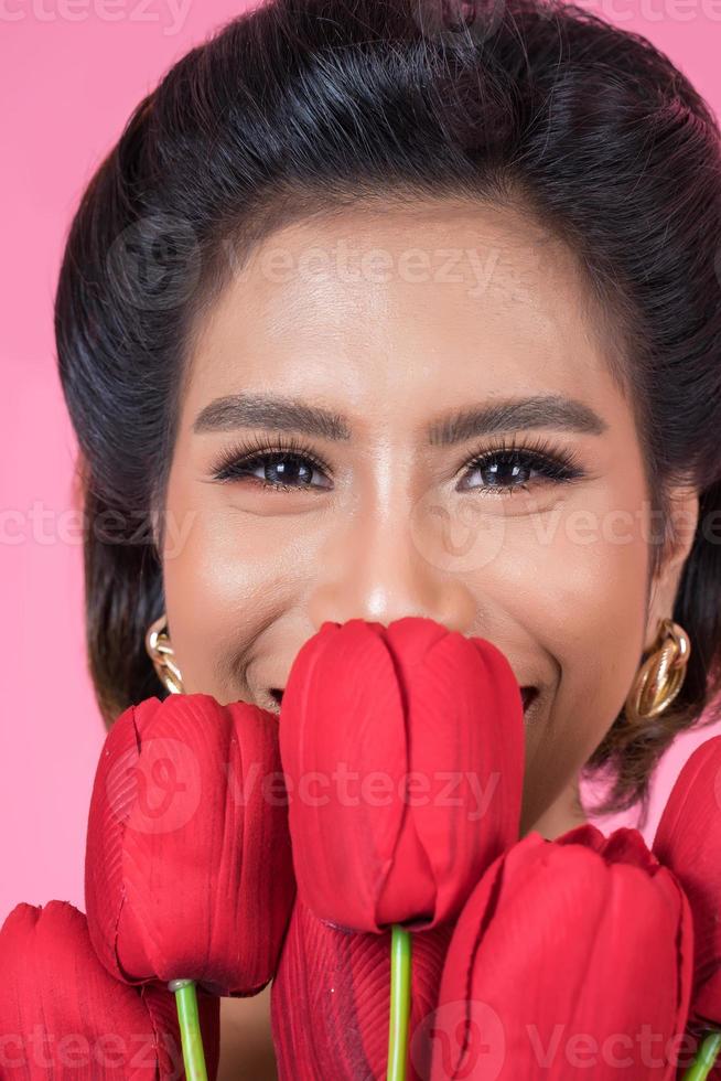 porträtt av en vacker kvinna med bukett med röda tulpanblommor foto