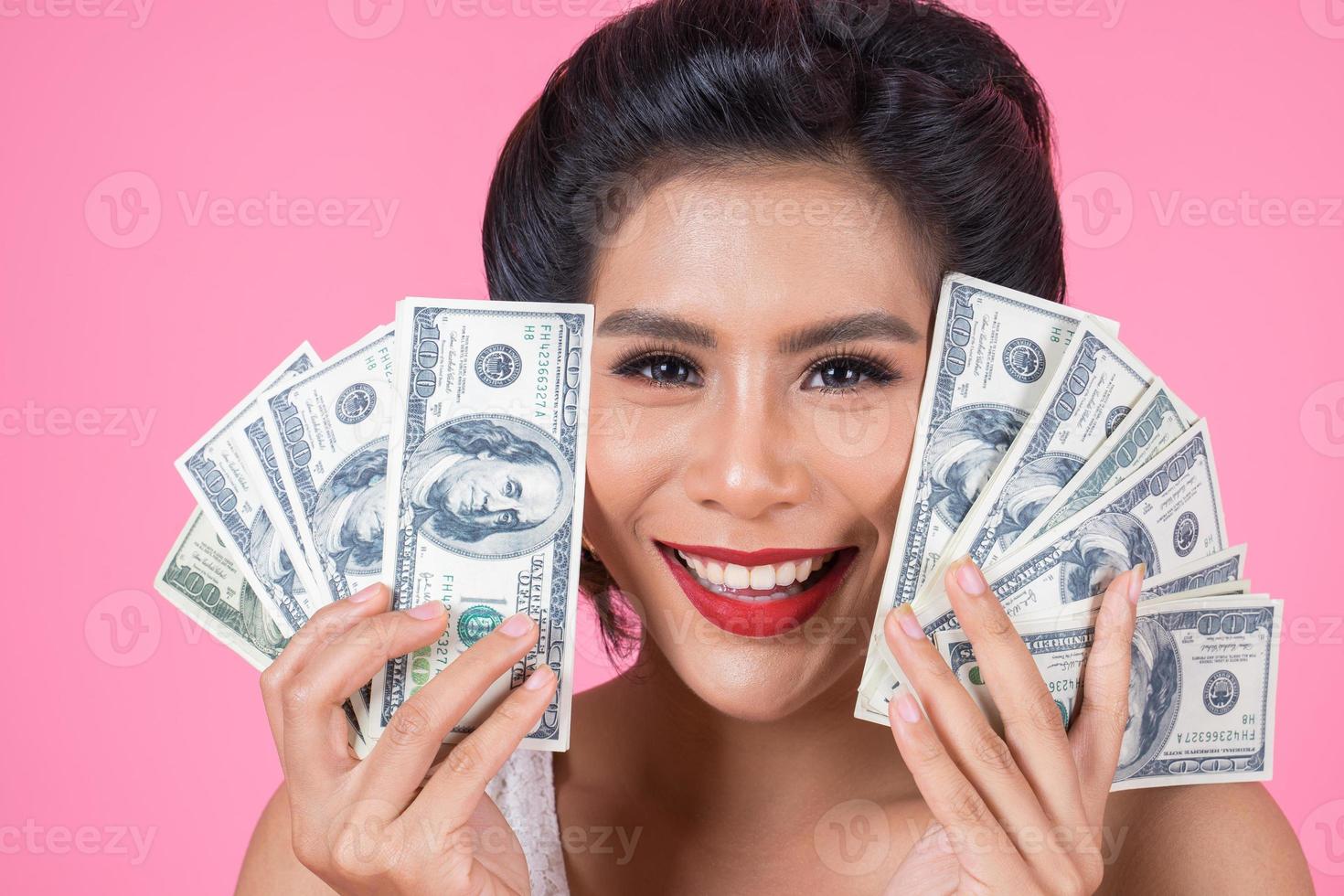 glad vacker kvinna med dollar foto