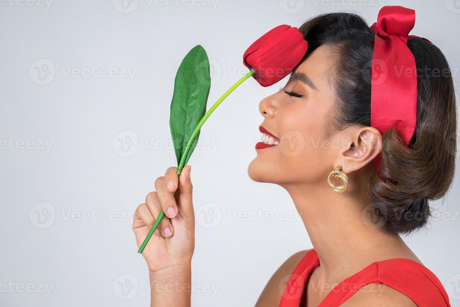 porträtt av en vacker kvinna med röda tulpanblommor foto
