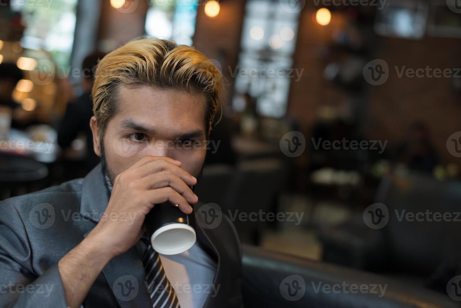 affärsman som dricker kaffe i stadskaféet under lunchtid foto