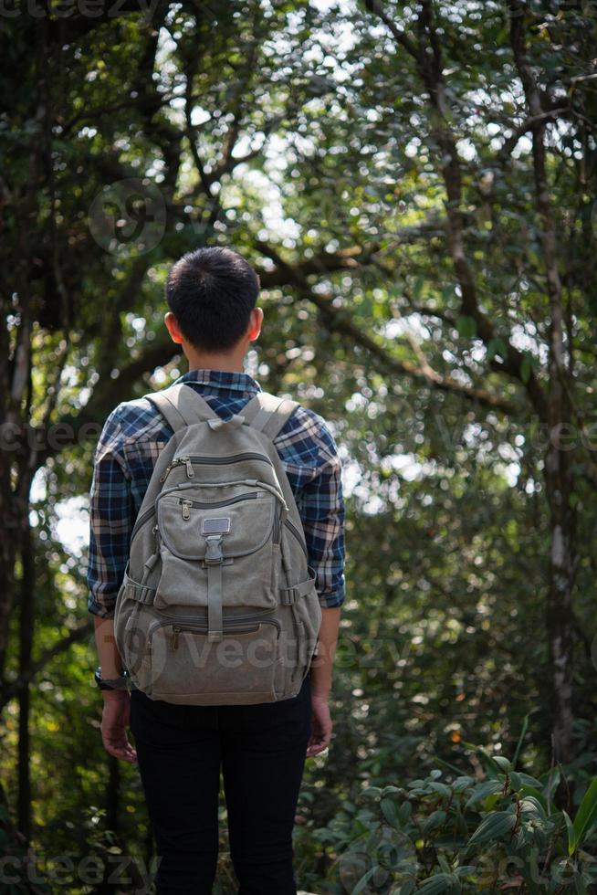 ung hipster man vandrare tar lite vila medan vandring foto