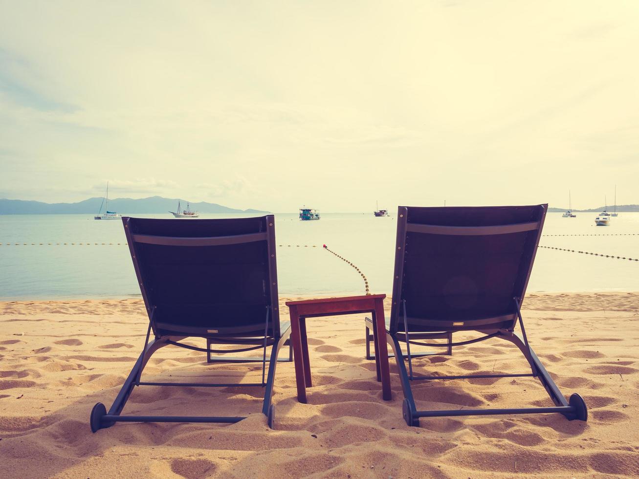 parasoller och solstolar på den tropiska stranden foto