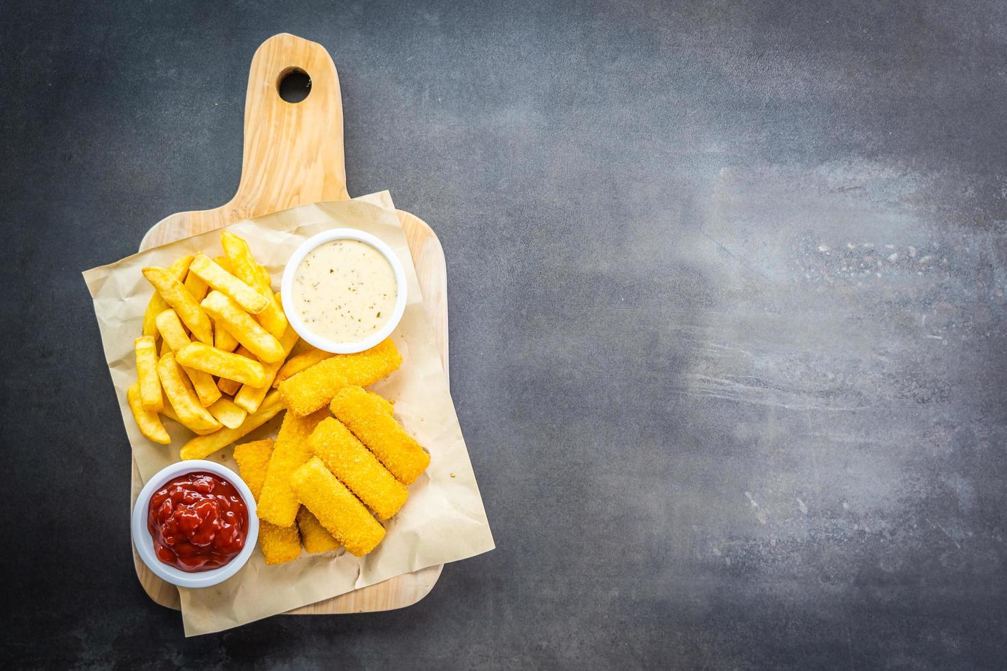 fiskfinger och pommes frites med tomatketchup och majonnässås foto