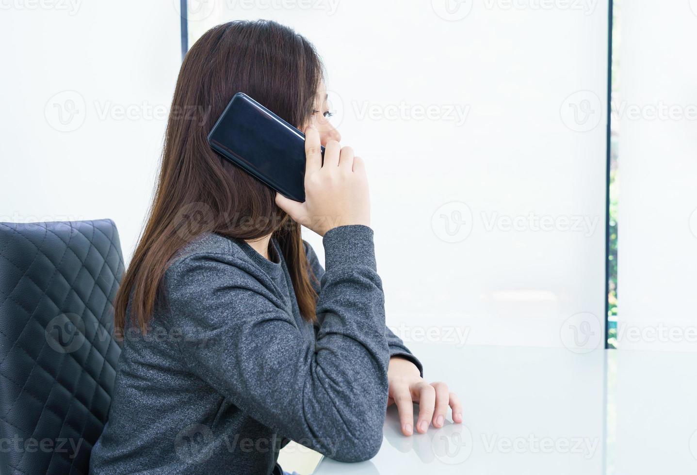 ung kvinna lång hår talande förbi mobil telefon foto
