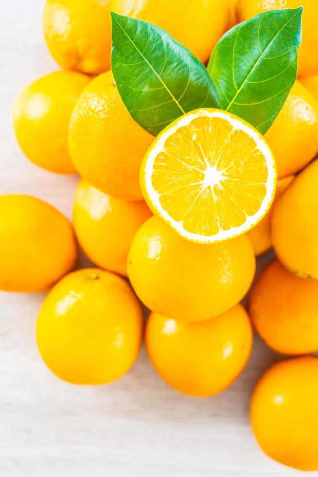 färska apelsiner på ett träbord foto