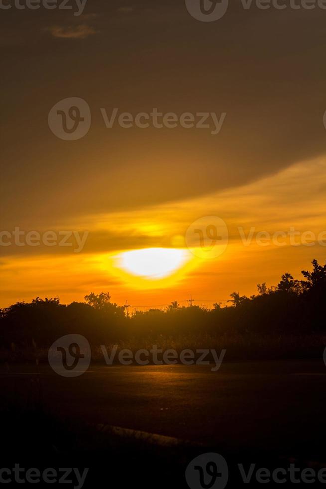 de stor Sol är handla om till uppsättning i de kväll som de himmel är en värma och skrämmande gul-orange, något natur har skapas i lantlig thailand. foto