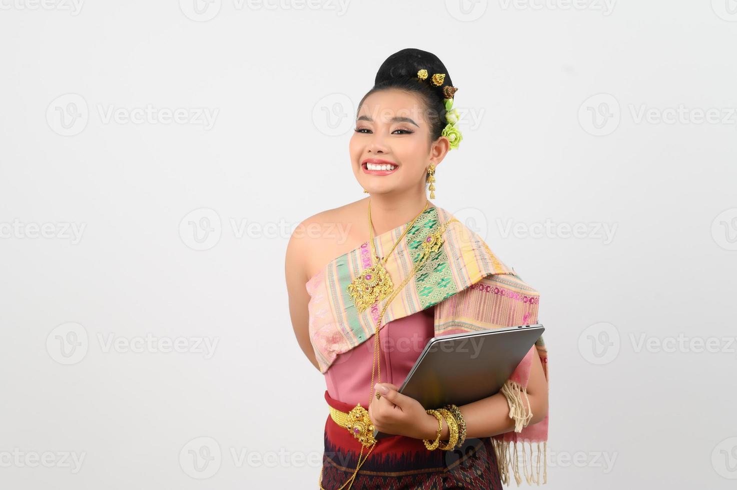 ung skön kvinna i nordöstra klänning innehav bärbar dator inlägg foto