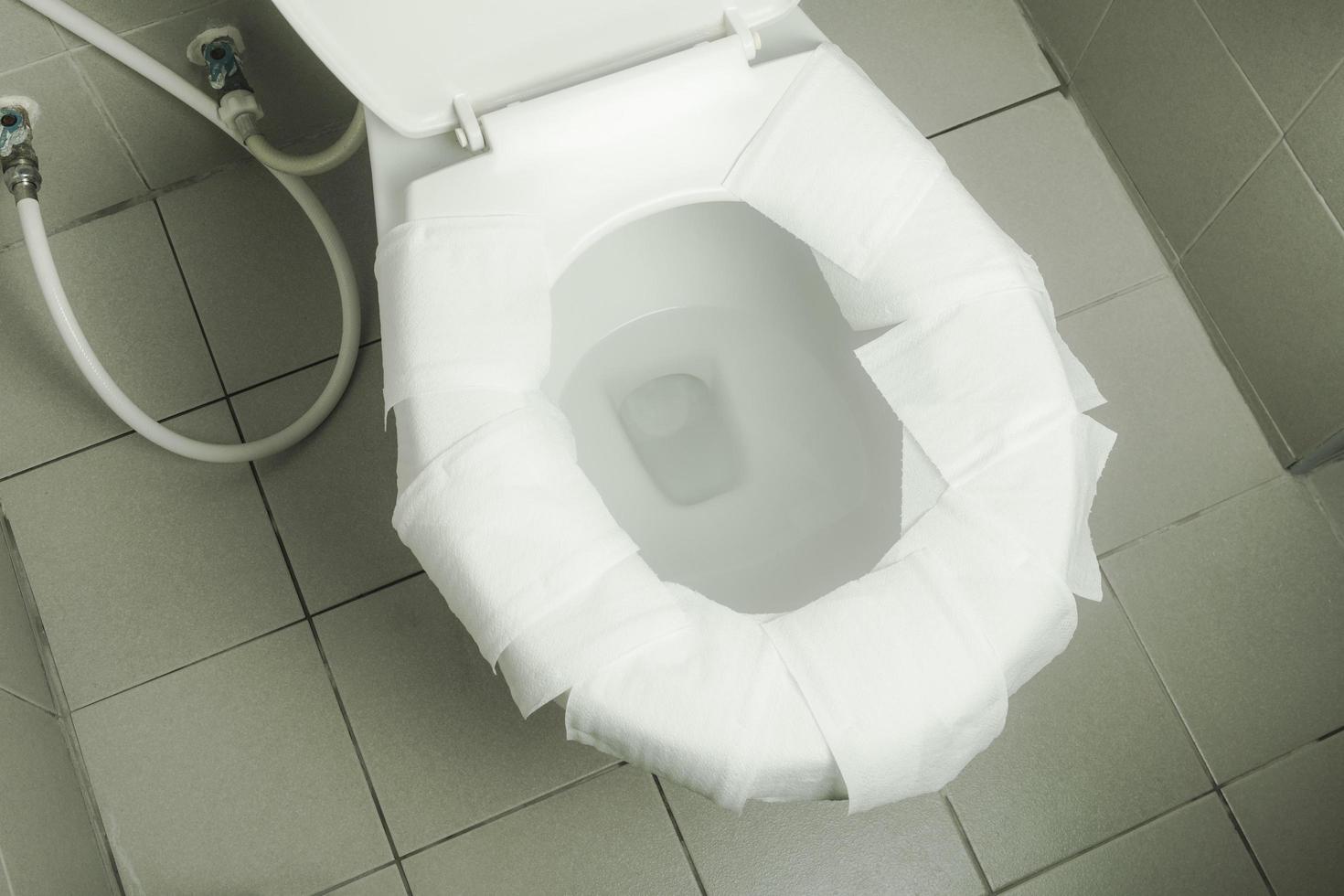 toalett papper plats på vit toalett skål foto