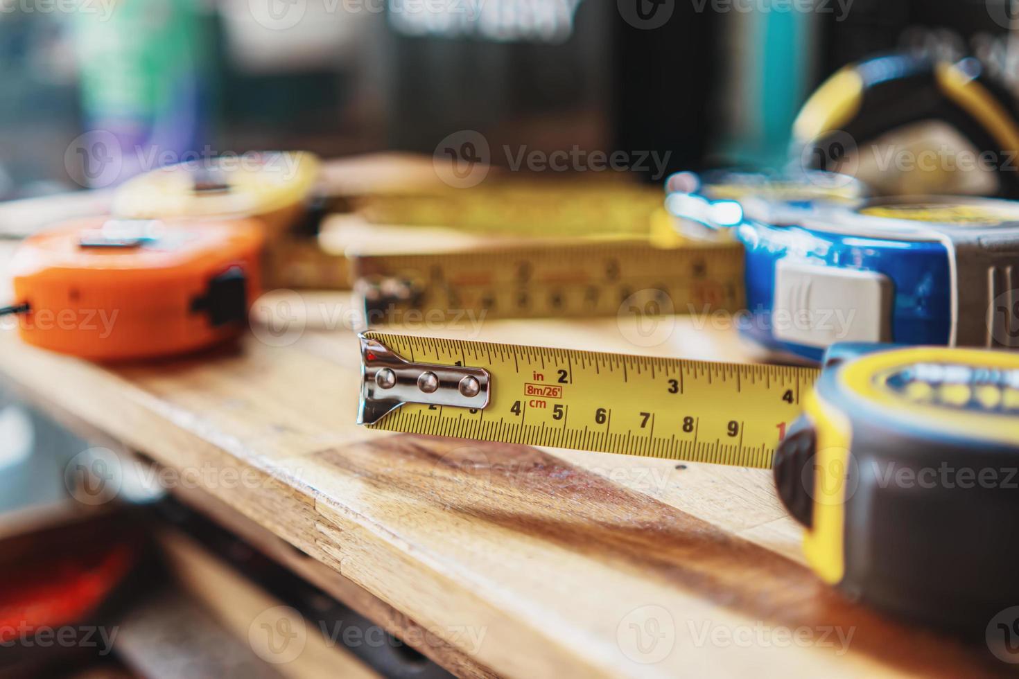 tejp mäta eller mätning tejp med linjärt mätt markeringar och snickeri hand verktyg på trä- skrivbord , diy tillverkare och träbearbetning begrepp. selektiv fokus foto