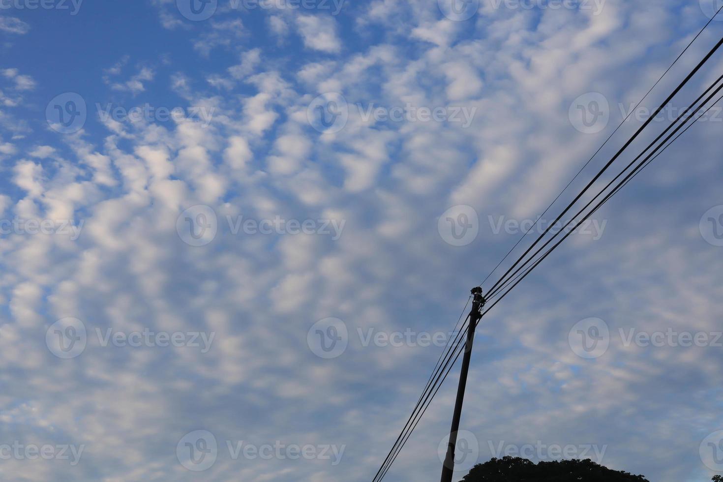 vit moln och Sol mot en bakgrund av blå himmel foto