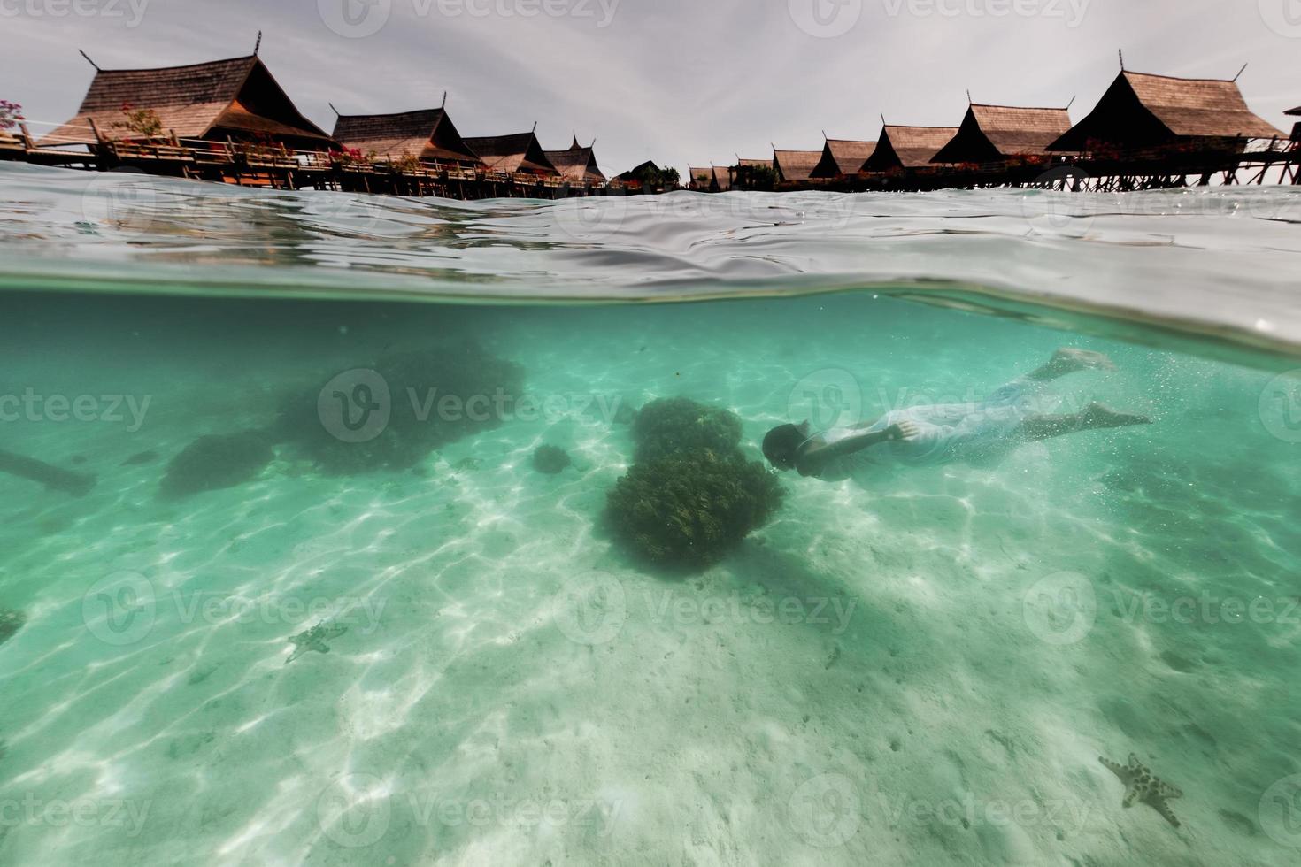 vit klädd flicka medan swiming under vattnet foto