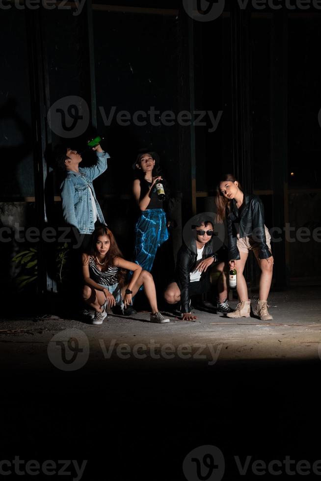 en grupp av tonåringar i knäppa kläder är njuter en fest tillsammans på de slutet av de år i ett gammal byggnad foto