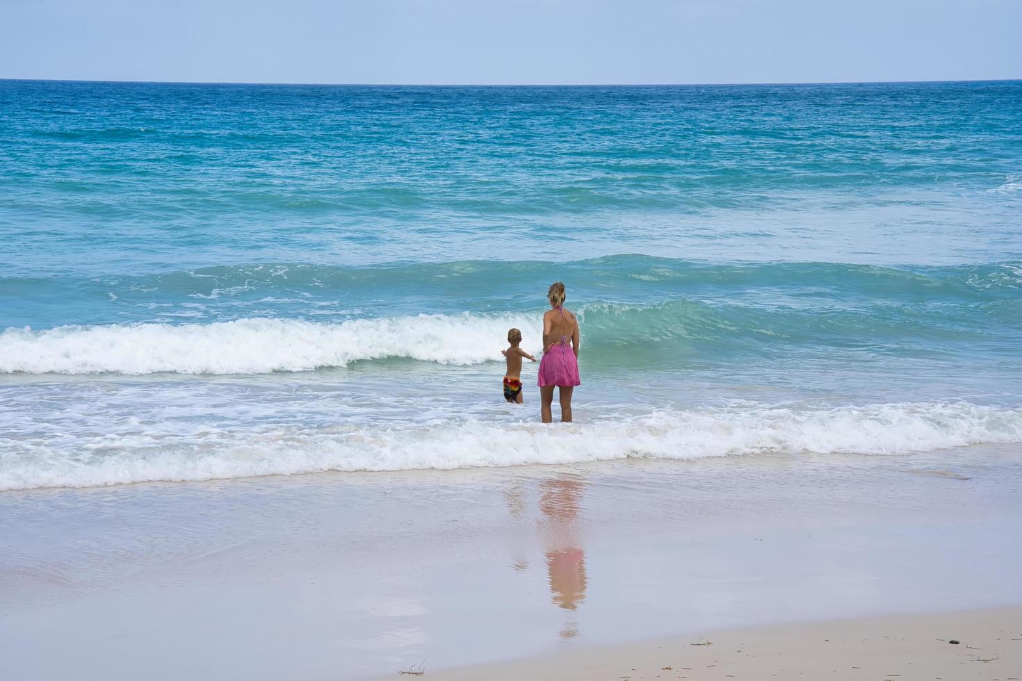 mahe Seychellerna 2023-02-02 klienter på de strand tittar på tittar på henne barn och de vågor foto